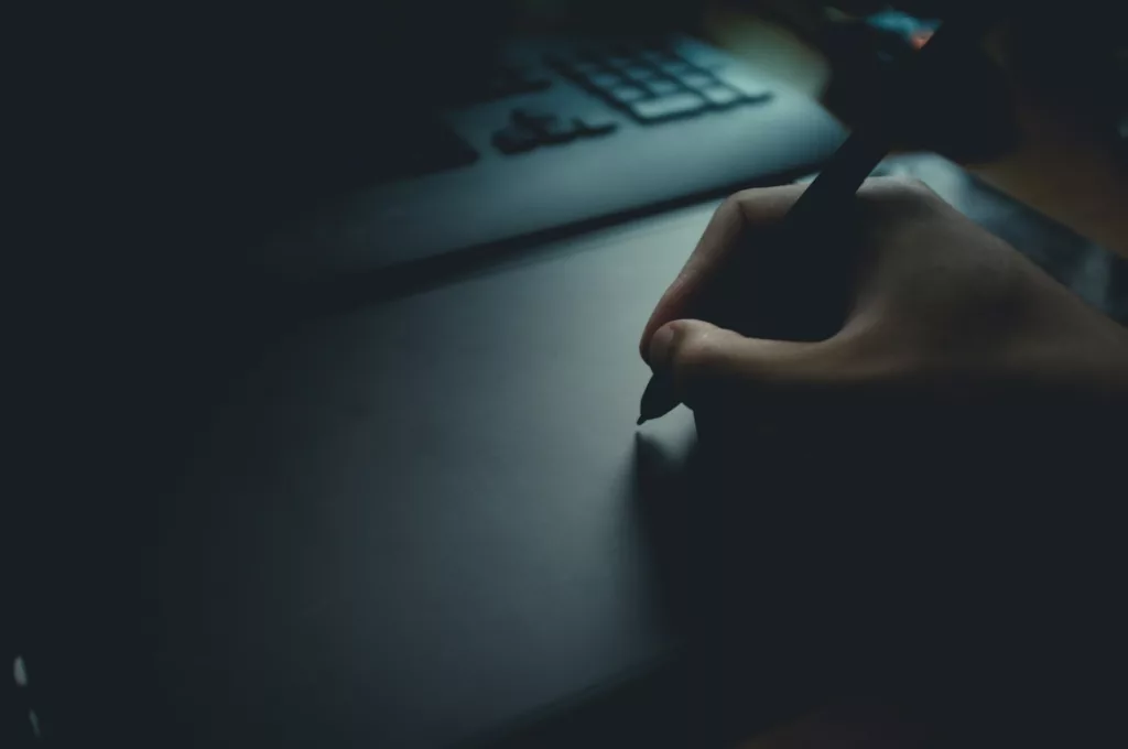 Main en train d'écrire devant un ordinateur